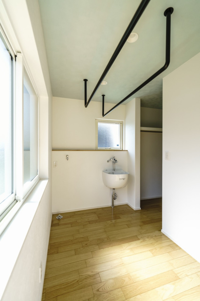 Пример оригинального дизайна: отдельная прачечная среднего размера в стиле модернизм с хозяйственной раковиной, белыми стенами, светлым паркетным полом, коричневым полом, потолком с обоями и обоями на стенах