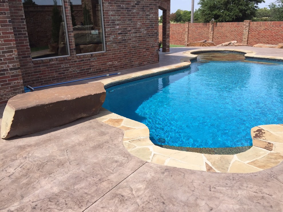 Example of a mid-sized island style backyard custom-shaped natural pool design in Oklahoma City