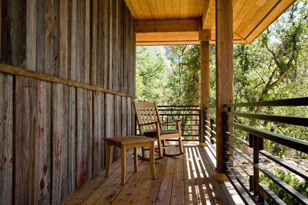 Small mountain style back porch photo in Denver with decking and a roof extension