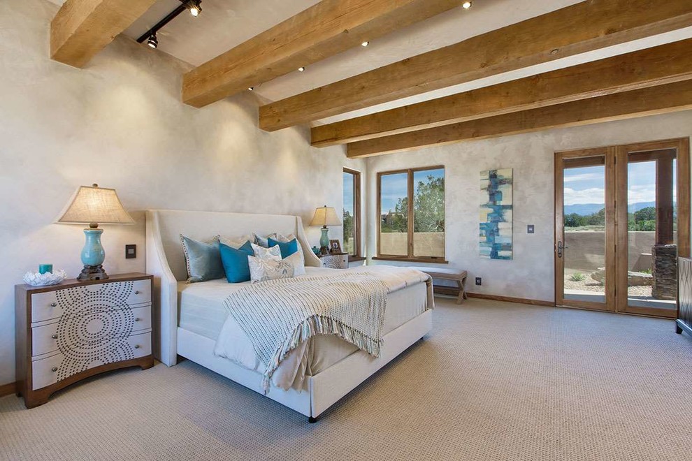 Large master bedroom in Albuquerque with beige walls, carpet, a corner fireplace and a stone fireplace surround.