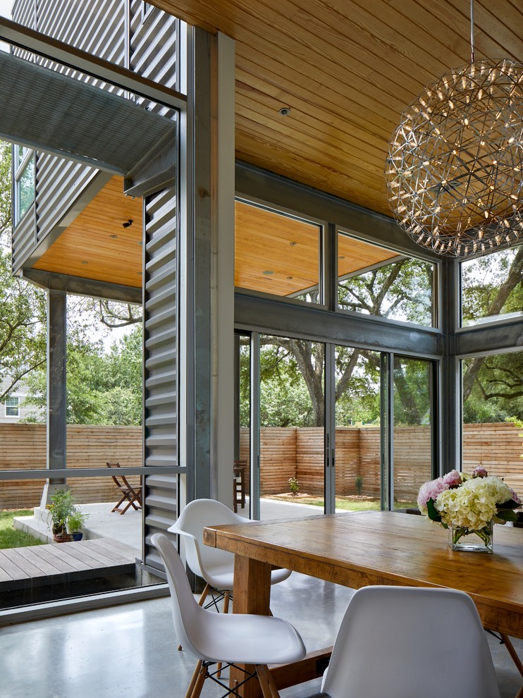 Inspiration for a mid-sized modern dining room in Houston with concrete floors and grey floor.