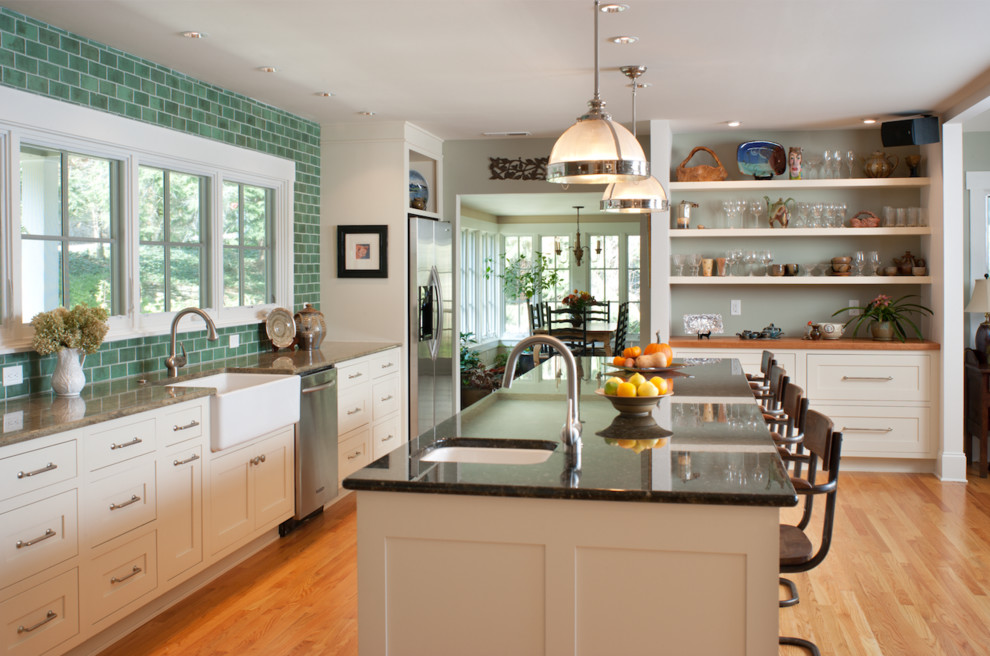 Inspiration for a large transitional open plan kitchen in Other with a farmhouse sink, shaker cabinets, white cabinets, green splashback, subway tile splashback, stainless steel appliances, medium hardwood floors, with island and brown floor.