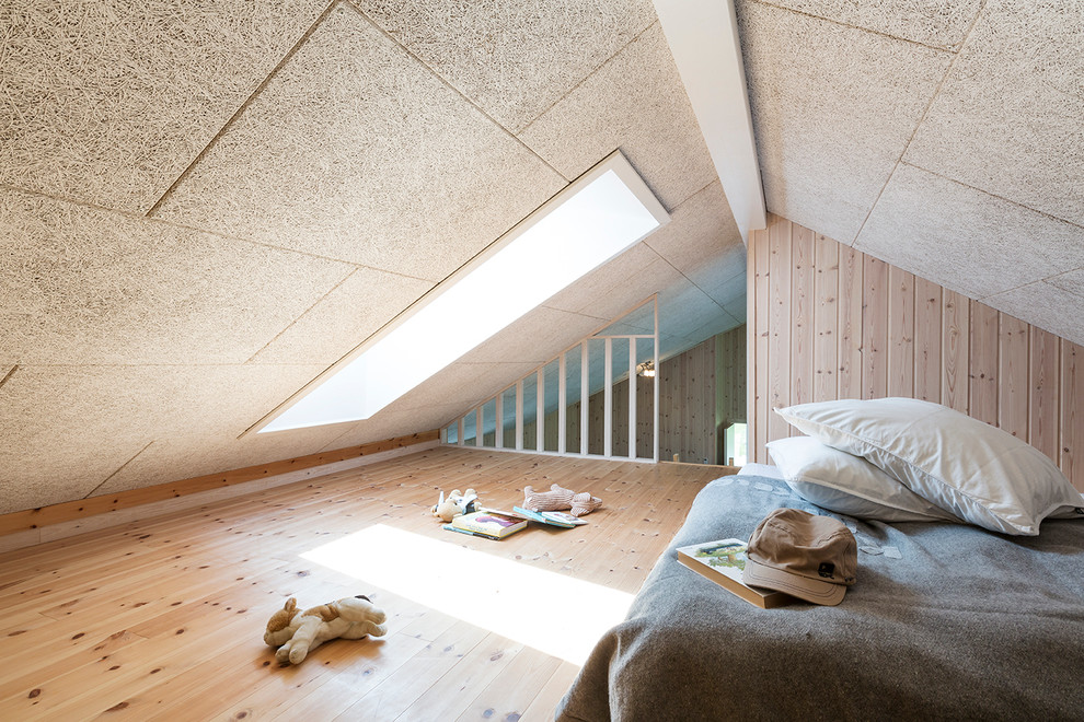 This is an example of a mid-sized scandinavian gender-neutral kids' bedroom for kids 4-10 years old in Aarhus with beige walls and light hardwood floors.