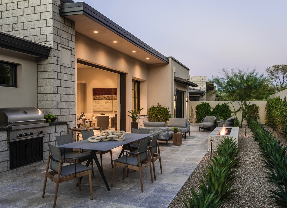 Large contemporary backyard patio in Phoenix with a fire feature, natural stone pavers and no cover.