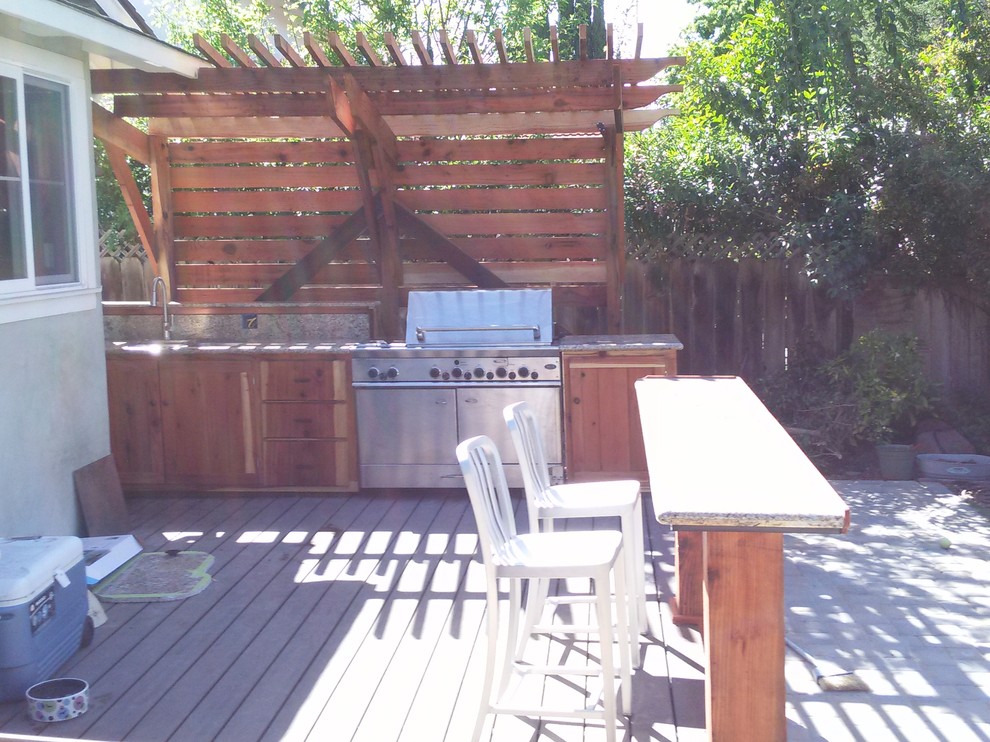 This is an example of a mid-sized country backyard patio in San Francisco with decking and a pergola.