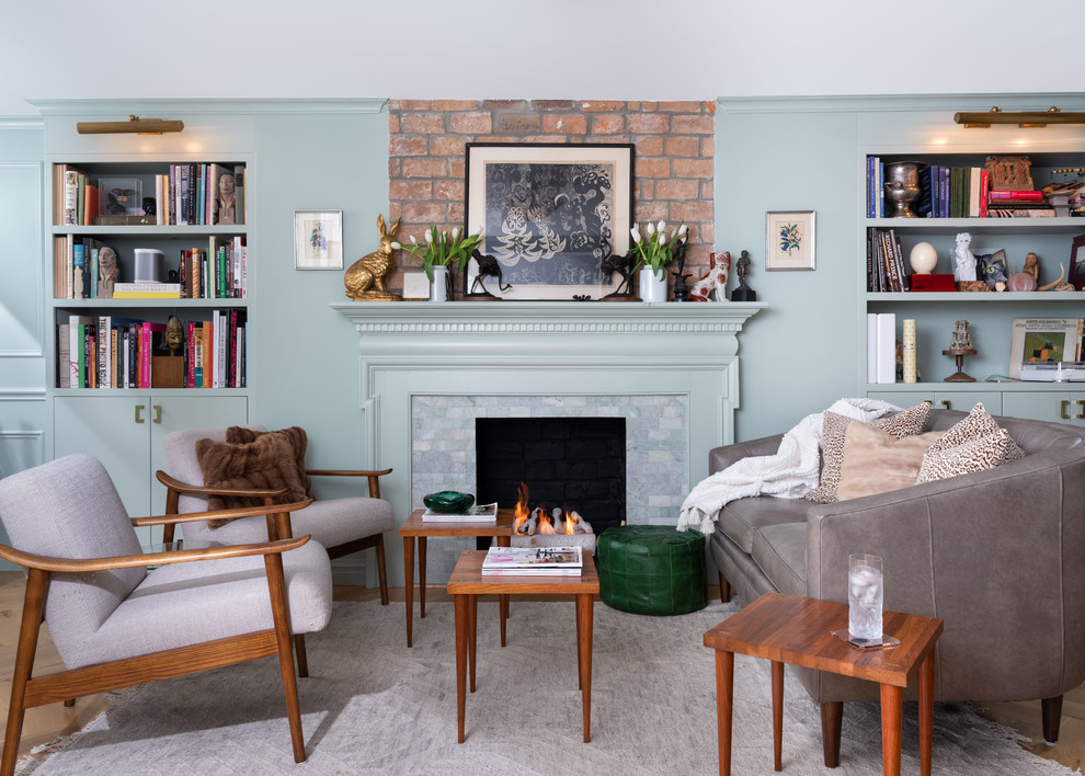 This is an example of a mid-sized eclectic open concept living room in New York with green walls, light hardwood floors, a standard fireplace, no tv, a library and a tile fireplace surround.