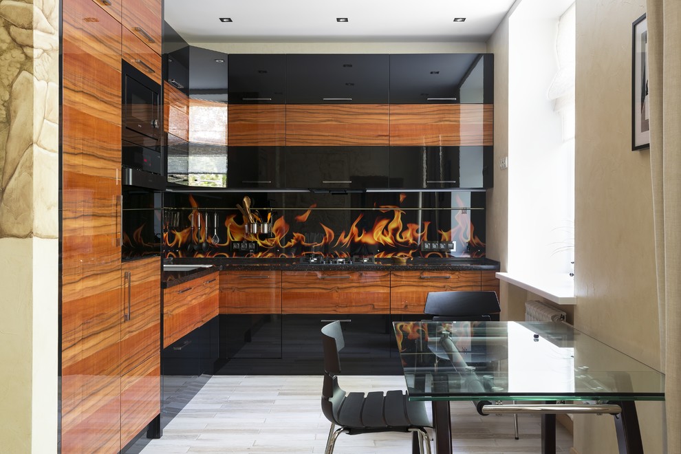 Inspiration for a mid-sized contemporary l-shaped eat-in kitchen in Moscow with an undermount sink, flat-panel cabinets, black cabinets, solid surface benchtops, orange splashback, glass sheet splashback, black appliances, porcelain floors, no island, beige floor and black benchtop.