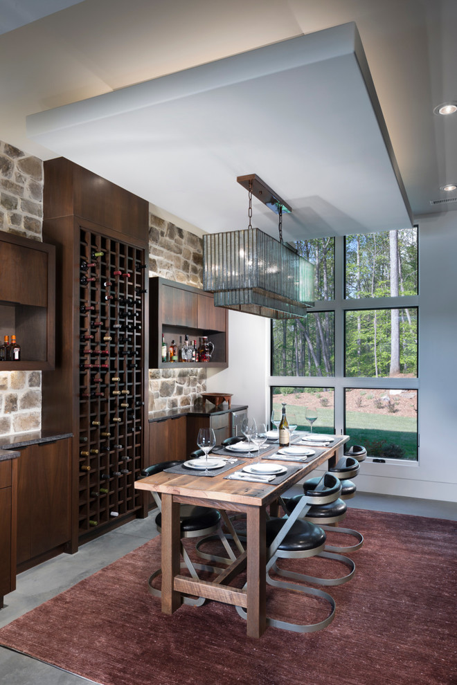 Mid-sized contemporary wine cellar in Other with concrete floors, storage racks and grey floor.