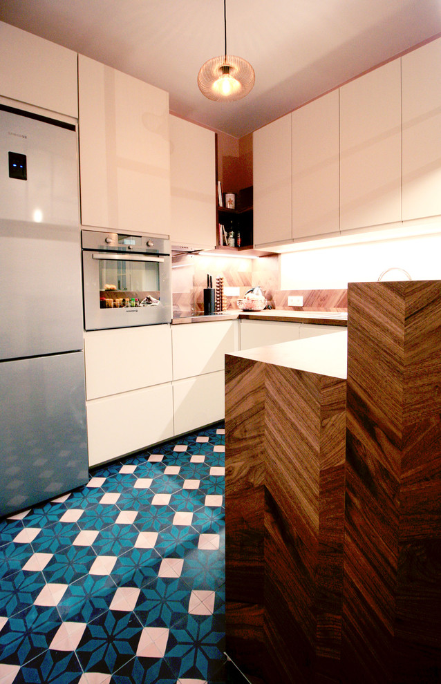 Inspiration for a mid-sized contemporary u-shaped eat-in kitchen in Paris with an undermount sink, beaded inset cabinets, beige cabinets, wood benchtops, brown splashback, timber splashback, panelled appliances, cement tiles, with island and turquoise floor.