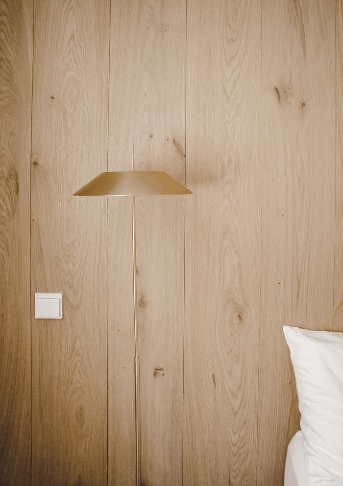 Mittelgroßes Mediterranes Hauptschlafzimmer mit hellem Holzboden, Kaminumrandung aus Holz, braunem Boden, brauner Wandfarbe und Eckkamin in Madrid