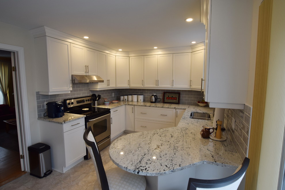 Example of a mid-sized transitional u-shaped ceramic tile enclosed kitchen design in Ottawa with an undermount sink, shaker cabinets, white cabinets, granite countertops, gray backsplash, glass tile backsplash, stainless steel appliances and a peninsula