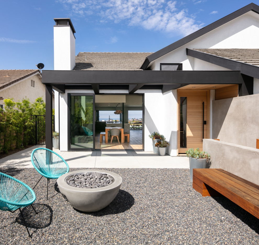 Photo of a medium sized modern front door in Orange County with white walls, concrete flooring, a pivot front door, a light wood front door, grey floors and a wood ceiling.