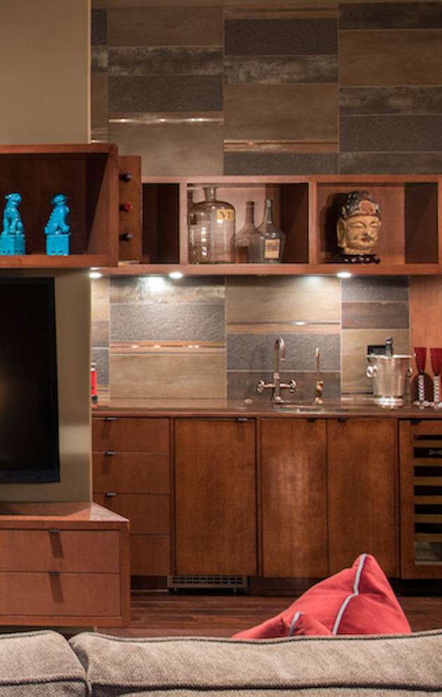 Photo of a small eclectic galley wet bar in Houston with an undermount sink, flat-panel cabinets, medium wood cabinets, copper benchtops, multi-coloured splashback, stone tile splashback, dark hardwood floors and brown floor.