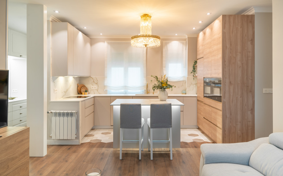Mid-sized transitional u-shaped eat-in kitchen in Other with an undermount sink, flat-panel cabinets, beige cabinets, tile benchtops, white splashback, porcelain splashback, black appliances, ceramic floors, with island, beige floor and white benchtop.