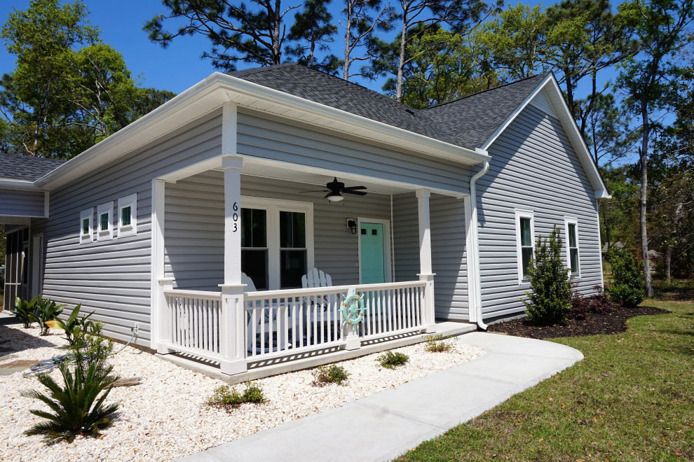 Kleines, Einstöckiges Maritimes Einfamilienhaus mit Vinylfassade, blauer Fassadenfarbe, Verschalung, Schindeldach und grauem Dach in Sonstige