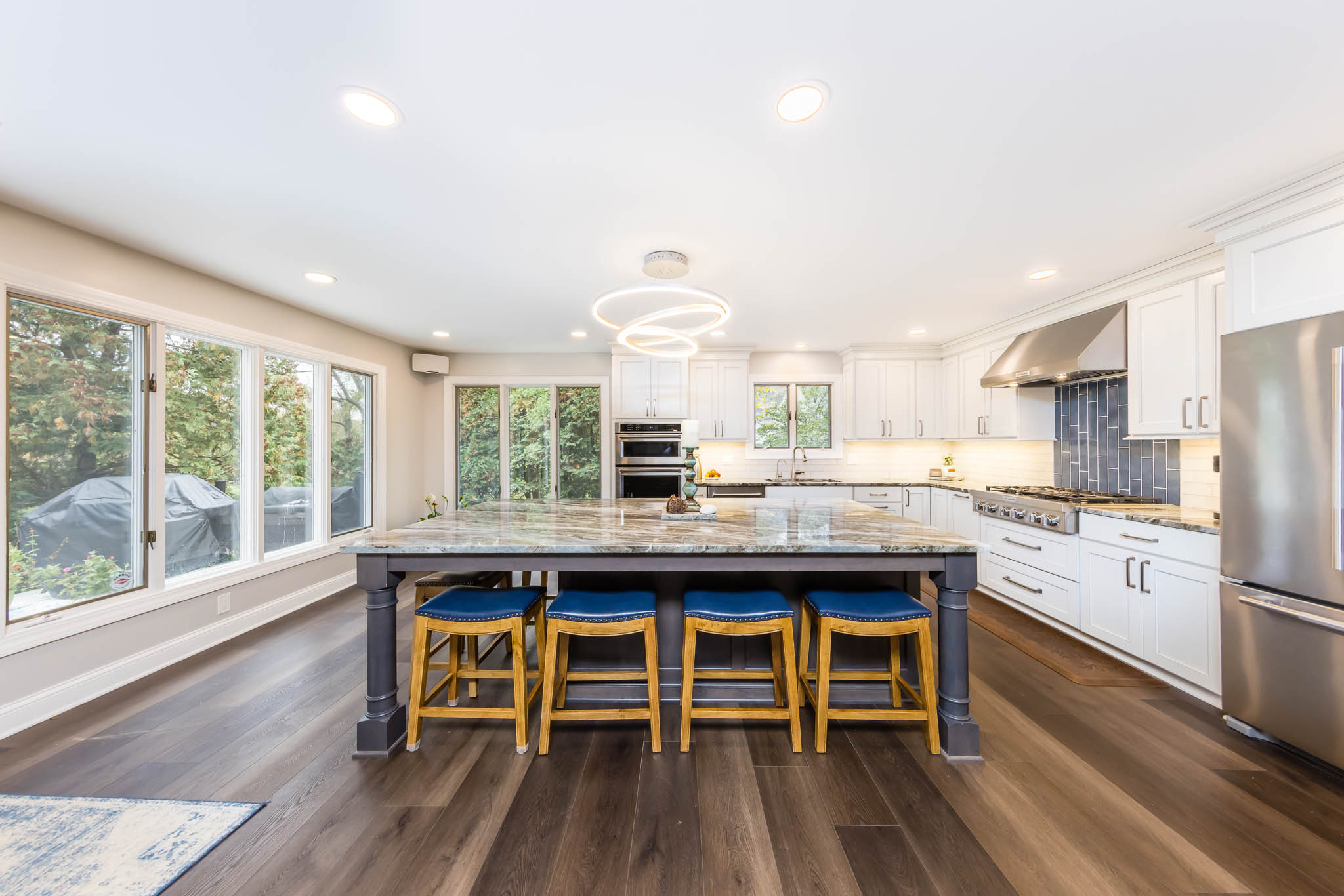 Example of a large beach style l-shaped medium tone wood floor and brown floor eat-in kitchen design in Columbus with an undermount sink, shaker cabinets, gray cabinets, quartzite countertops, white b