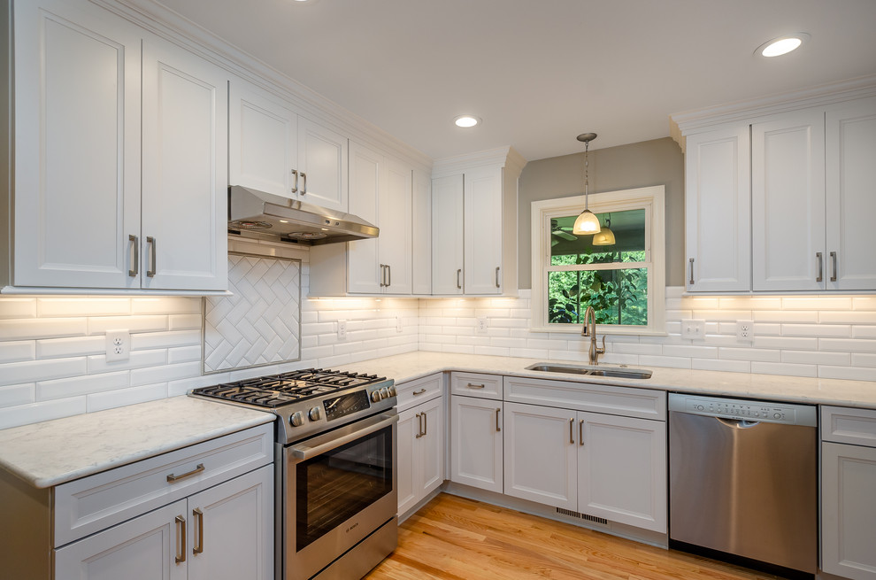 Inspiration for a small transitional l-shaped medium tone wood floor and brown floor eat-in kitchen remodel with a double-bowl sink, shaker cabinets, gray cabinets, quartz countertops, white backsplash, subway tile backsplash, stainless steel appliances, no island and white countertops