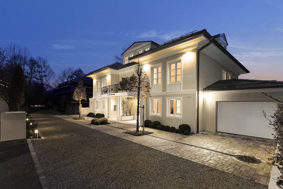 Large traditional three-storey stucco beige house exterior in Munich with a hip roof.