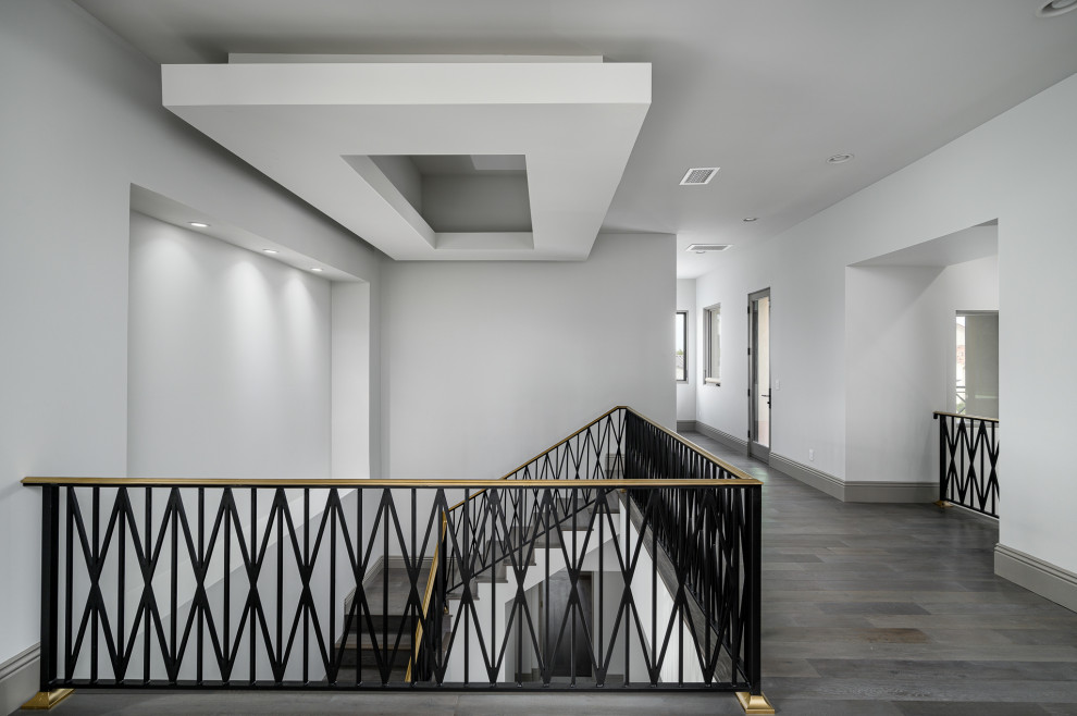 Imagen de escalera en L minimalista de tamaño medio con escalones de madera pintada, contrahuellas de madera pintada y barandilla de metal