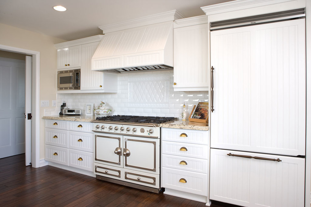 Photo of a traditional kitchen in Orange County with white splashback, subway tile splashback and panelled appliances.