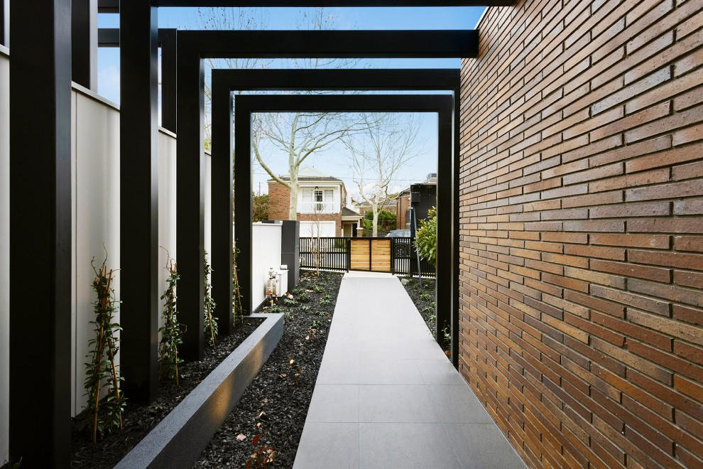 Ispirazione per la facciata di una casa a schiera marrone moderna con rivestimento in mattoni e copertura in tegole