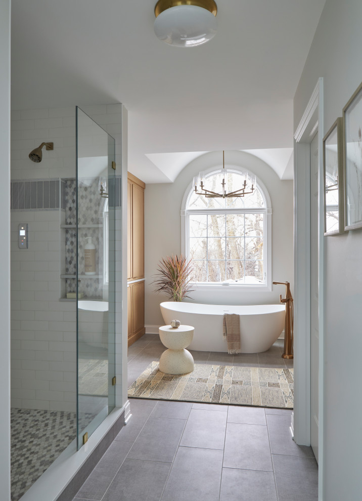Inspiration for a large transitional master bathroom in Chicago with beaded inset cabinets, brown cabinets, a freestanding tub, an open shower, white tile, white walls, ceramic floors, a drop-in sink, quartzite benchtops, grey floor, a sliding shower screen, white benchtops, a niche, a double vanity and a built-in vanity.