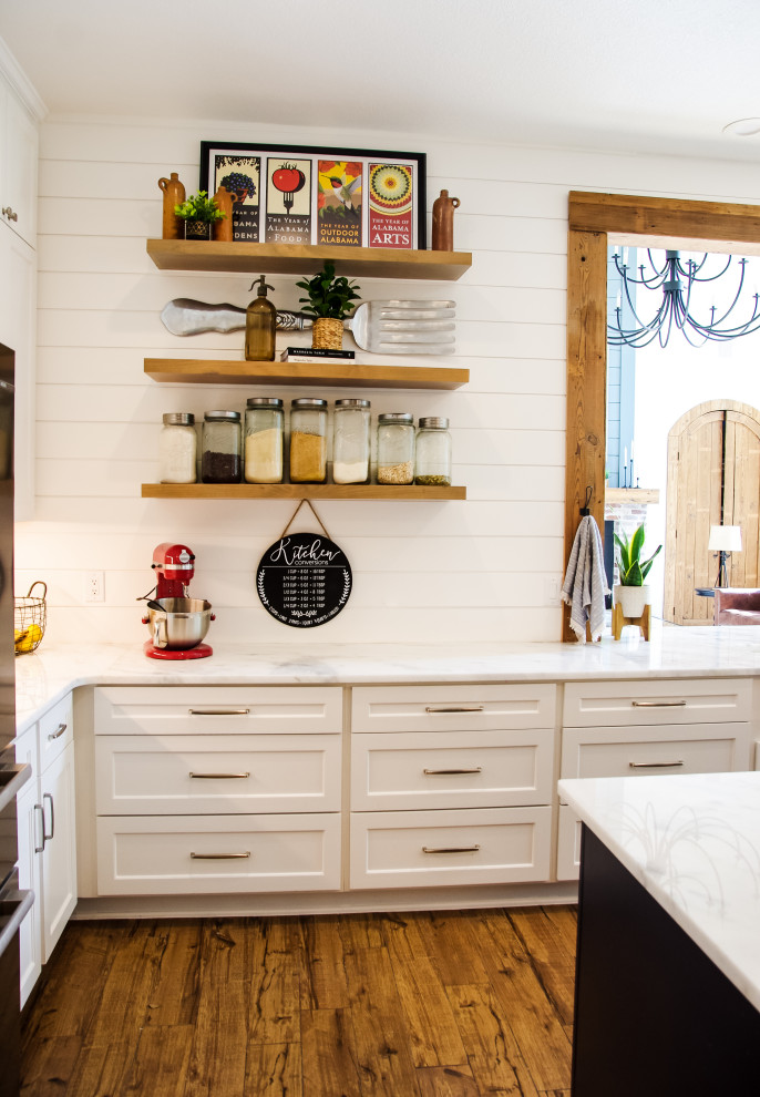 Kitchen - transitional medium tone wood floor and brown floor kitchen idea with a farmhouse sink, marble countertops, brick backsplash, stainless steel appliances, an island and multicolored countertops