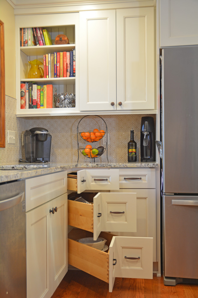 Foto på ett mellanstort vintage grå kök, med en undermonterad diskho, luckor med infälld panel, vita skåp, granitbänkskiva, beige stänkskydd, stänkskydd i porslinskakel, rostfria vitvaror, mellanmörkt trägolv, en köksö och brunt golv