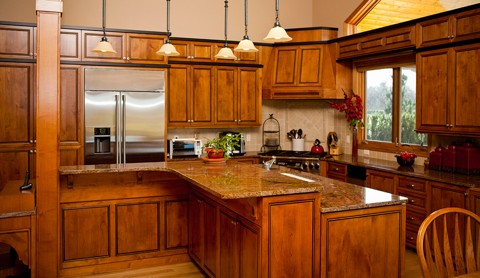Inspiration for a mid-sized traditional l-shaped eat-in kitchen in Portland with a drop-in sink, beaded inset cabinets, medium wood cabinets, granite benchtops, beige splashback, terra-cotta splashback, stainless steel appliances, medium hardwood floors and with island.