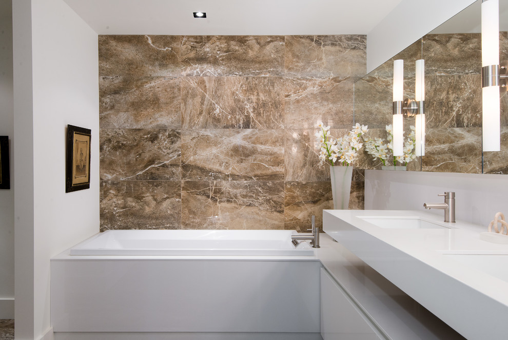 Photo of a mid-sized modern master bathroom in Vancouver with a drop-in tub, brown tile, stone tile, white walls, flat-panel cabinets, white cabinets, an undermount sink, engineered quartz benchtops and white benchtops.