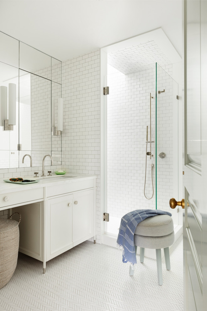 Example of a mid-sized transitional master white tile and ceramic tile ceramic tile, white floor and double-sink alcove shower design in New York with recessed-panel cabinets, white cabinets, white walls, a drop-in sink, marble countertops, a hinged shower door, white countertops and a built-in vanity