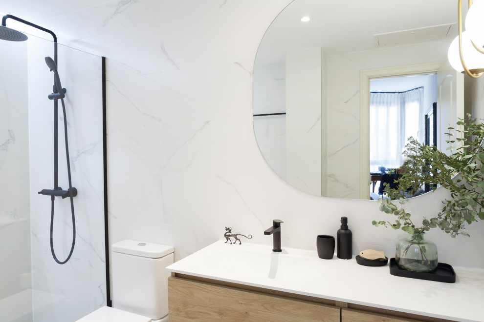 Photo of a mid-sized contemporary master bathroom in Madrid with furniture-like cabinets, white cabinets, a curbless shower, a one-piece toilet, black and white tile, ceramic tile, white walls, ceramic floors, an integrated sink, engineered quartz benchtops, grey floor, a hinged shower door, white benchtops, a niche, a single vanity and a built-in vanity.