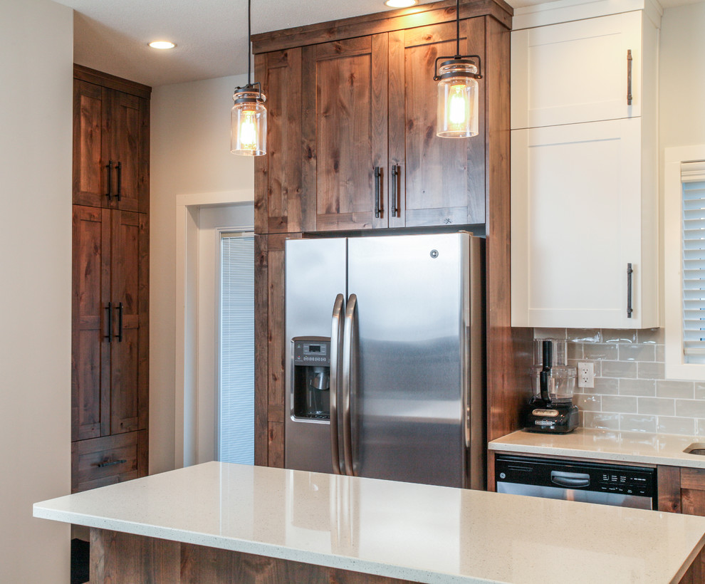 Inspiration for a large transitional l-shaped medium tone wood floor eat-in kitchen remodel in Calgary with an undermount sink, shaker cabinets, dark wood cabinets, quartz countertops, gray backsplash, subway tile backsplash, stainless steel appliances and an island