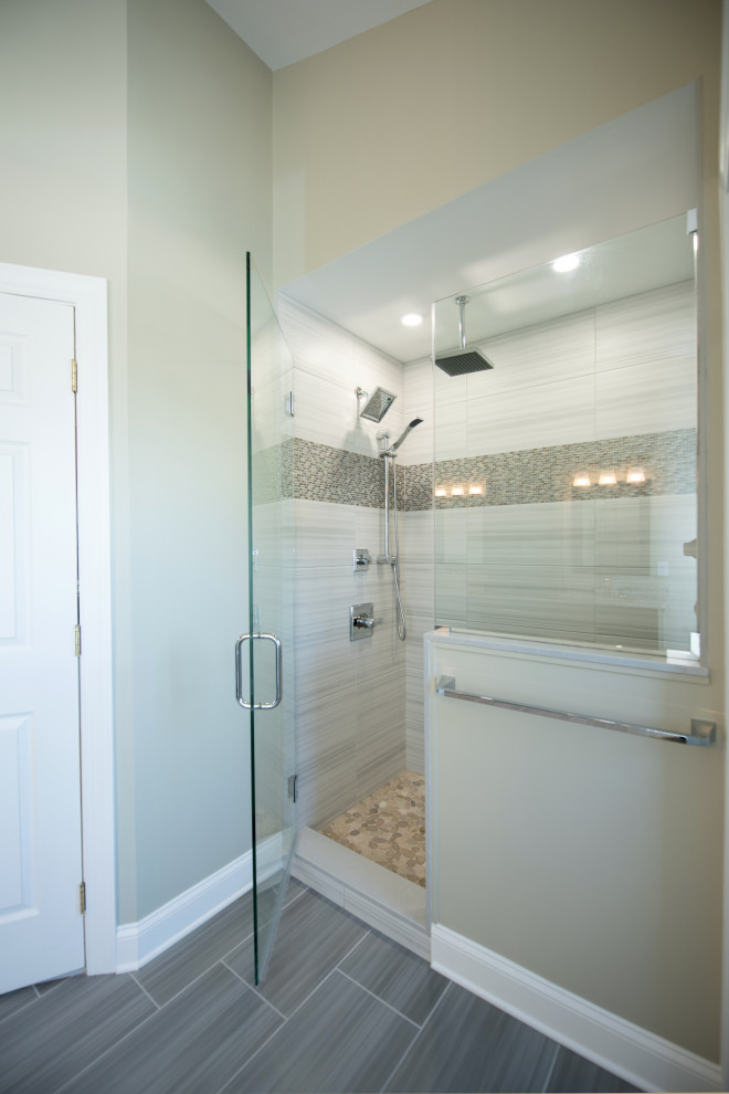 На фото: главная ванная комната среднего размера в стиле модернизм с фасадами с утопленной филенкой, серыми фасадами, отдельно стоящей ванной, двойным душем, раздельным унитазом, разноцветной плиткой, плиткой мозаикой, бежевыми стенами, полом из галечной плитки, врезной раковиной, столешницей из гранита, серым полом, душем с распашными дверями, сиденьем для душа, тумбой под две раковины, встроенной тумбой и сводчатым потолком с