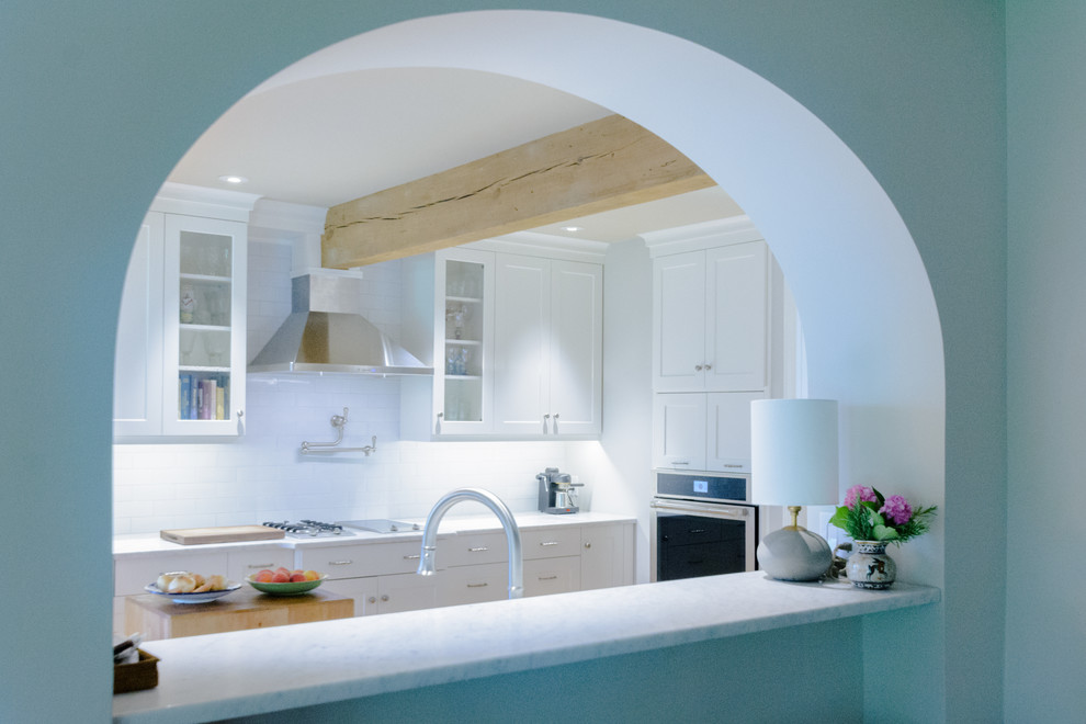 Inspiration for a mid-sized transitional galley enclosed kitchen remodel in Charleston with white cabinets, white backsplash, no island and white countertops