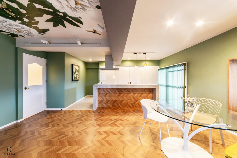 Cette image montre un salon bohème ouvert avec un mur vert, un sol en bois brun, un plafond en papier peint, du papier peint et un sol marron.