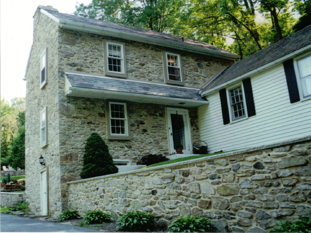 Design ideas for an expansive country two-storey beige exterior in Philadelphia with stone veneer.