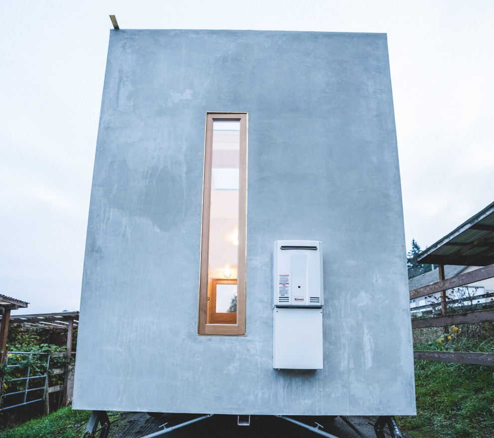 Inspiration för små moderna grå betonghus, med allt i ett plan och platt tak