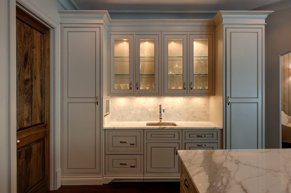 Inspiration for a large transitional u-shaped medium tone wood floor home design remodel in Atlanta with a farmhouse sink, beaded inset cabinets, white cabinets, marble countertops, white backsplash, porcelain backsplash, paneled appliances and an island
