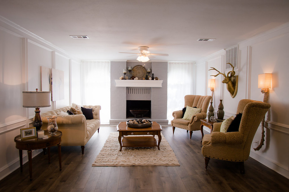 Photo of a country formal enclosed living room in Houston with white walls, dark hardwood floors, a standard fireplace, a brick fireplace surround, no tv and brown floor.