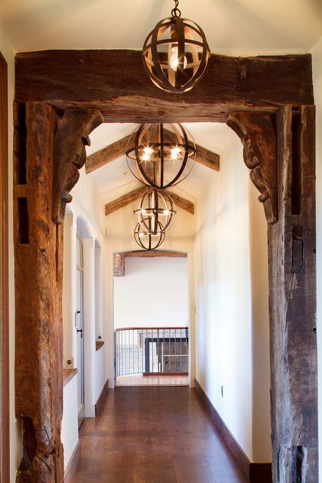 Inspiration for a mid-sized country hallway in Other with white walls, dark hardwood floors and brown floor.