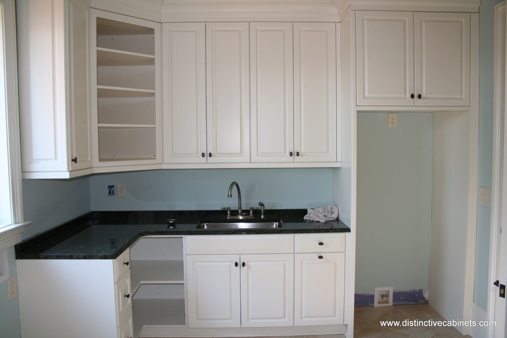 Inspiration for a traditional laundry room in Charlotte with raised-panel cabinets and white cabinets.