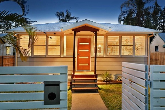 Design ideas for a transitional one-storey beige exterior in Townsville with a hip roof.
