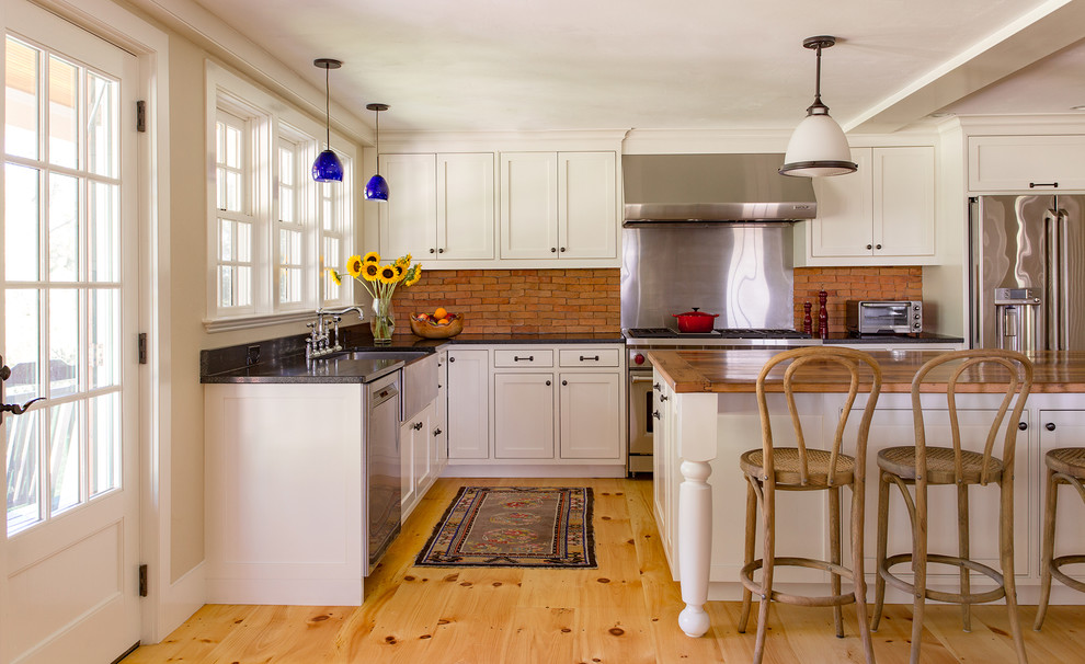 Inspiration for a large country l-shaped kitchen in Boston with a farmhouse sink, white cabinets, granite benchtops, brown splashback, stainless steel appliances, with island, shaker cabinets and medium hardwood floors.
