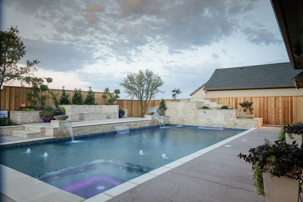 Mid-sized transitional backyard rectangular lap pool in Austin with a water slide and concrete slab.