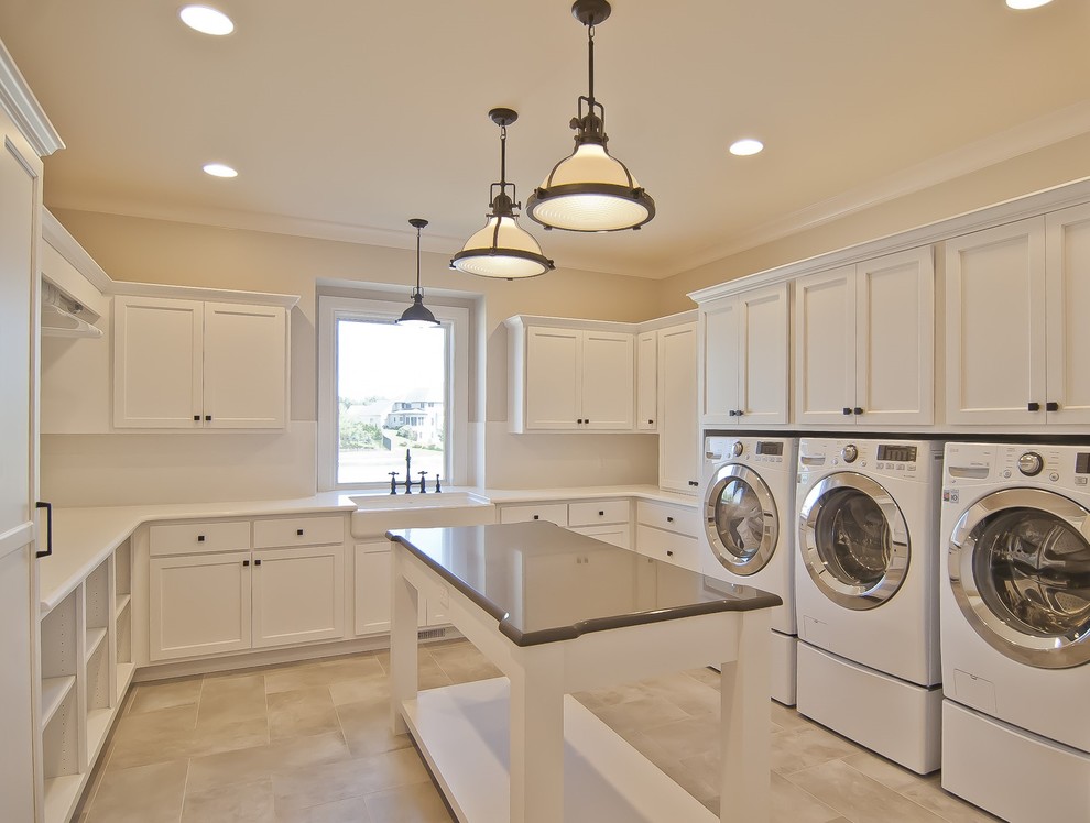 Example of a transitional laundry room design with a farmhouse sink, shaker cabinets, white cabinets, quartz countertops and a side-by-side washer/dryer