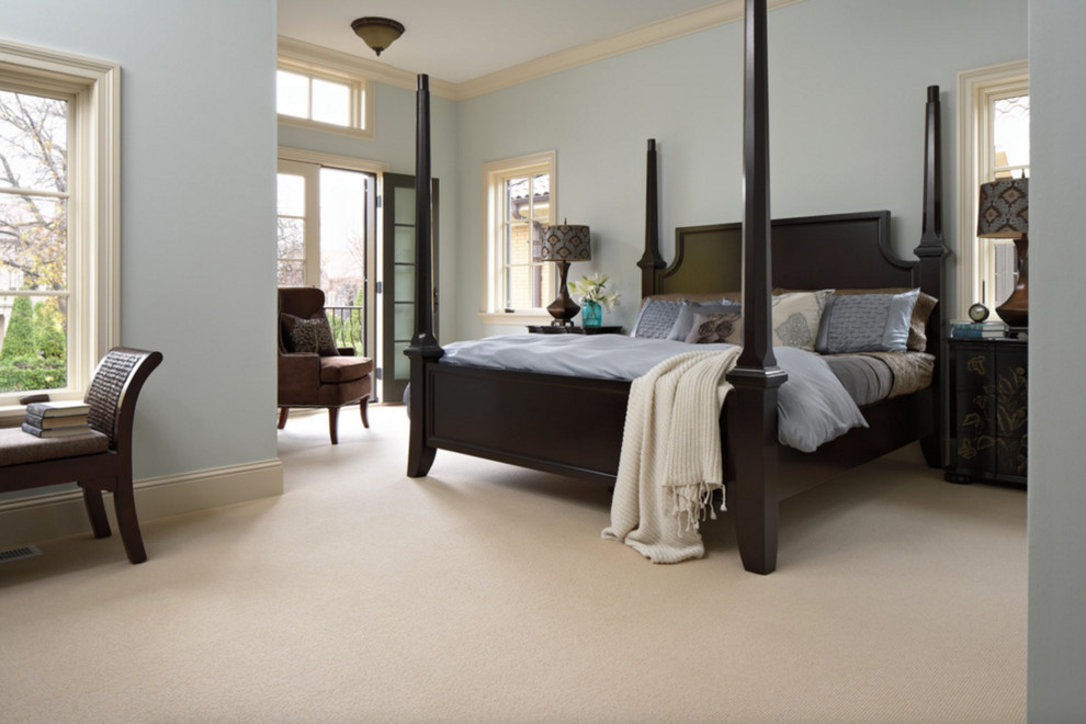 Inspiration for a large traditional master bedroom in New York with blue walls, carpet, no fireplace and beige floor.