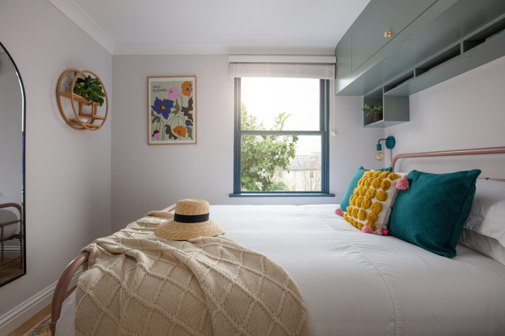Idee per una camera degli ospiti bohémian di medie dimensioni con pareti bianche, pavimento in legno massello medio e pavimento marrone