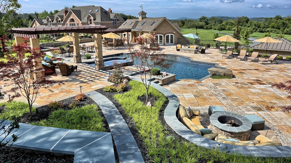 Inspiration for a large modern backyard custom-shaped pool in Philadelphia with a water feature and concrete pavers.