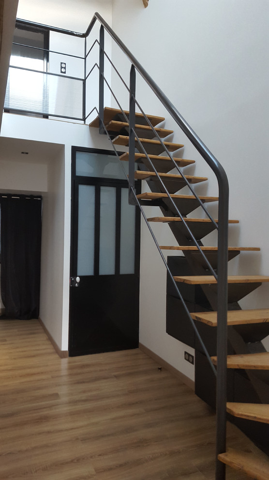This is an example of a mid-sized industrial wood l-shaped staircase in Toulouse with metal risers and metal railing.